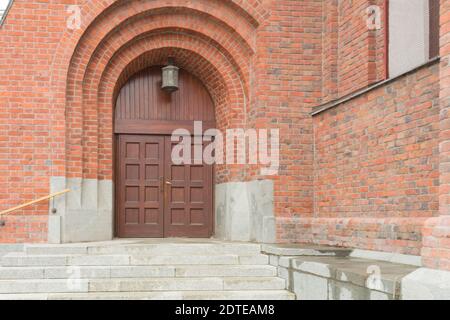 Porte massive vintage contre un mur rouge. Grandes portes en bois sous l'arche Banque D'Images