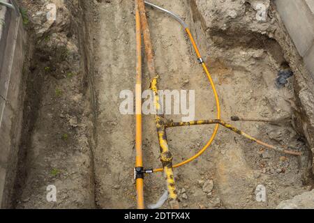 Tranchée clôturée avec services publics souterrains. Travaux de réparation de pipelines de gaz dans une rue urbaine, liaison de gazoducs Banque D'Images