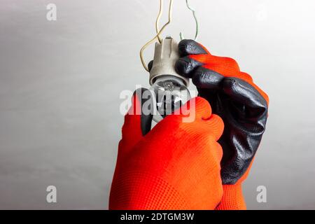 L'assistant électrique change une ancienne ampoule Banque D'Images