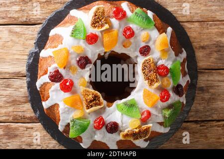 Livre de gâteau avec des baies séchées et des fruits et glaçage en gros plan sur une planche sur la table. Vue horizontale du dessus Banque D'Images