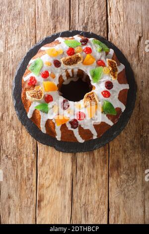 Gâteau de fête avec fruits secs et glaçage en gros plan sur le plateau de la table. Vue verticale du dessus Banque D'Images