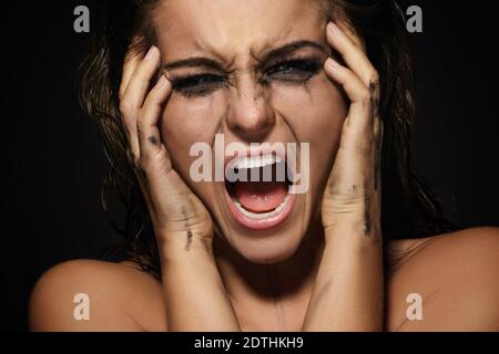 Triste et belle femme avec des bavures maquillage sur son visage Banque D'Images