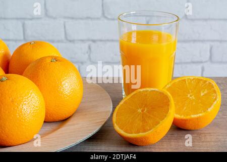 Les oranges et le verre de jus d'orange Banque D'Images