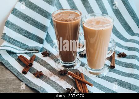 Café glacé avec lait dans de grands verres, tasses de café savoureux de frappe, Latte machiato, deux tasses de cappuccino avec des bâtons de cannelle et des étoiles anis, adver Banque D'Images