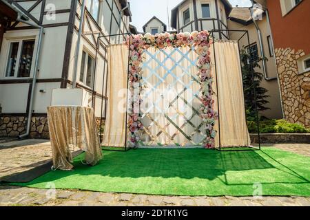 Décor de mariage. La zone de cérémonie de mariage dans l'arrière-cour est décorée de fleurs blanches et roses et de tissus dorés. Banque D'Images