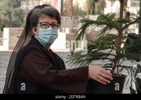 Jérusalem, Israël. 22 décembre 2020. Le Père Noël, ou « Baba Noel » comme il est appelé en arabe, se déplace à dos de chameau pour remplacer le renne près de la porte Jaffa de la vieille ville de Jérusalem. La municipalité de Jérusalem et le Fonds national juif ont distribué des cyprès d'Arizona spécialement cultivés à la population chrétienne à la porte de Jaffa. Crédit : NIR Amon/Alamy Live News Banque D'Images