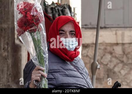 Jérusalem, Israël. 22 décembre 2020. Le Père Noël, ou « Baba Noel » comme il est appelé en arabe, se déplace à dos de chameau pour remplacer le renne près de la porte Jaffa de la vieille ville de Jérusalem. La municipalité de Jérusalem et le Fonds national juif ont distribué des cyprès d'Arizona spécialement cultivés à la population chrétienne à la porte de Jaffa. Crédit : NIR Amon/Alamy Live News Banque D'Images