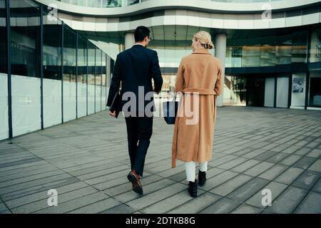 Les collègues d'affaires se promentent pour travailler en lien avec les clients tout en parlant de ces derniers Banque D'Images