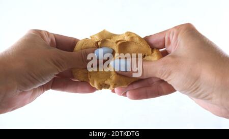 Les mains femelles sont moulées à partir de plasticité d'or, développant des activités pour les enfants. Banque D'Images