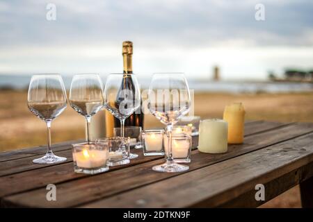 Tout est prêt pour la fin de l'année toast en vacances d'hiver au bord de la mer - scène de célébration avec un accent sélectif sur les verres vides, bouteille de champagne fermée Banque D'Images