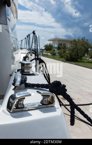 Détail d'une corde d'ancrage sur un yacht de luxe. Amarrage de yacht à moteur. Amarrer un bateau sur un oeil en acier inoxydable avec une corde attachée sur le pont blanc d'un yacht Banque D'Images