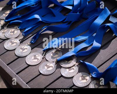 Médailles de dressage de chevaux avec ruban bleu sur une table en bois. Banque D'Images