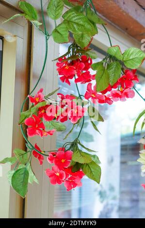 Un cliché vertical de fausses fleurs suspendues dans un panier Banque D'Images