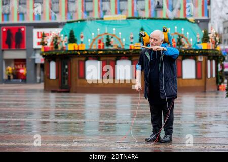 Essen, Allemagne. 22 décembre 2020. Michael laisse ses deux perroquets Chikko et Chikka (macaw) voler sur Kennedyplatz devant un stand de Noël fermé. L'Essener laisse ses deux perroquets voler régulièrement - également dans le centre-ville - à l'extérieur. Credit: Rolf Vennenbernd/dpa/Alay Live News Banque D'Images