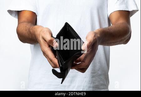 Homme noir méconnu montrant un portefeuille vide sur fond blanc Banque D'Images