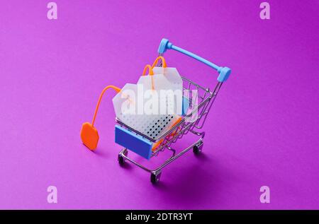 Sachets de thé dans un chariot à jouets sur fond violet. Photo conceptuelle. Banque D'Images