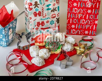 Assortiment de biscuits de Noël sur un tableau rouge avec vacances emballages et ruban Banque D'Images