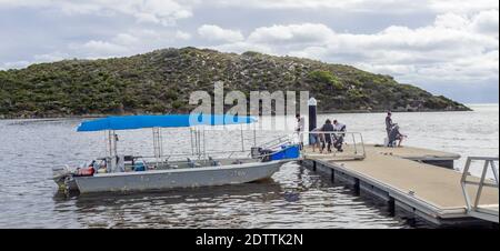 Deux hommes pêchent et des personnes embarquant à bord d'un petit bateau en aluminium dans l'estuaire de la rivière Moore Guilderton en Australie occidentale. Banque D'Images