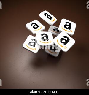 Logos de la société de commerce électronique et de cloud computing Amazon tombant sur une table sombre. Espace de copie et mise au point sélective Banque D'Images