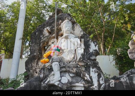 Phayao, Thaïlande - 29 novembre 2020 : statue de Wukong ou de Roi singe sur pierre et bâton avec fond de forêt Banque D'Images