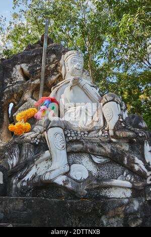 Phayao, Thaïlande - 29 novembre 2020 : Portrait de soleil de marbre Wukong ou Statue du Roi singe sur la pierre et le bâton avec fond forestier Banque D'Images