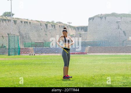 Athlète féminine arrosée d'eau dans des vêtements de sport mesurant la taille Banque D'Images
