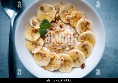 Flocons d'avoine avec banane, noix et miel dans un bol blanc fermé. Santé naturelle manger des aliments Banque D'Images