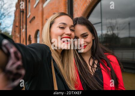 Deux jeunes amis qui prennent un selfie à l'extérieur. Banque D'Images