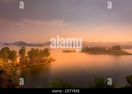 Lac Mutanda au coucher du soleil avec vue sur les volcans Mont Muhavuru et Mont Gahinga en Afrique de l'est, le long de la frontière du Rwanda et de l'Ouganda. Banque D'Images