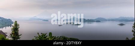 Panorama du lac Mutanda le matin avec vue sur les volcans Mont Muhavuru et Mont Gahinga en Afrique de l'est, le long de la frontière du Rwanda et de l'Ouganda. Banque D'Images