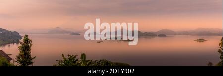 Panorama du lac Mutanda le matin avec vue sur les volcans Mont Muhavuru et Mont Gahinga en Afrique de l'est, le long de la frontière du Rwanda et de l'Ouganda. Banque D'Images