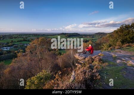 Walker jouissant de la vue sur la plaine du Cheshire depuis le point de vue de Kitty's Stone, Bickerton Hill, Cheshire, Angleterre, Royaume-Uni Banque D'Images