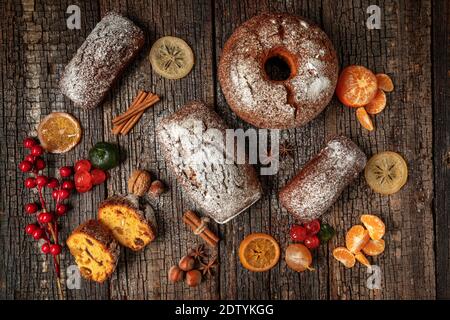 Composition de Noël de fruits secs et de stollen, avec de la mandarine, sur une table texturée en bois, avec des épices. À Noël. Banque D'Images