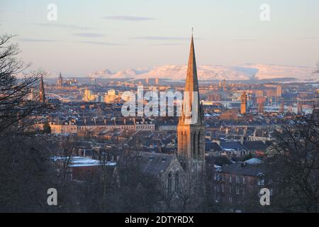 Le soleil du soir glisse sur les toits de Glasgow, en Écosse, et illumine les collines enneigées des coquillages de CAMPSIE au nord. Banque D'Images