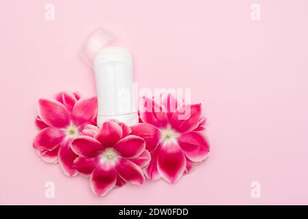 déodorant antisudorifique pour le corps avec fleurs sur fond rose avec un copier l'espace Banque D'Images