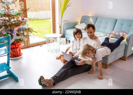 Père essayant de travailler de la maison avec ses enfants Banque D'Images