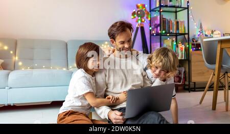 Père essayant de travailler de la maison avec ses enfants Banque D'Images