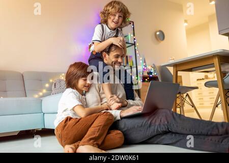 Père essayant de travailler de la maison avec ses enfants Banque D'Images