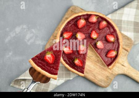 Tarte aux fraises aux baies fraîches. Pelle à gâteau avec morceau de tarte avec garniture de fruits, foyer sélectif Banque D'Images