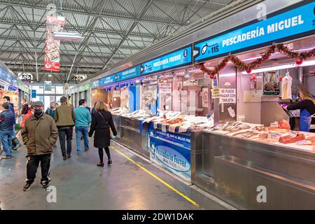 Huelva, Espagne - 11 décembre 2020 : intérieur du marché Mercado del Carmen. Les personnes portant un masque de protection dû au coronavirus COVID-19 Banque D'Images