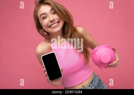 Photo de belle jeune femme souriante belle apparence porter décontracté tenue élégante isolée sur l'arrière-plan avec espace pour les copies smartphone Banque D'Images