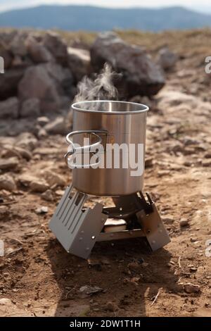 Fer, mugs touristiques sur un feu ouvert pendant un voyage de camping Banque D'Images