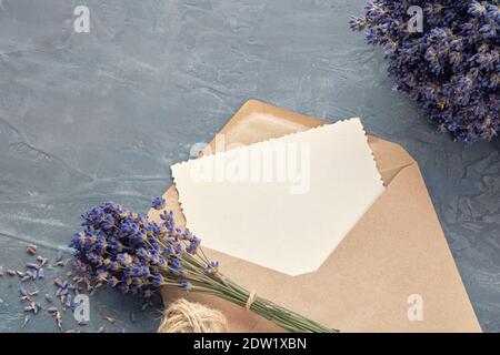 Carte de voeux et bouquets de fleurs de lavande sur fond gris. Pose à plat. Banque D'Images