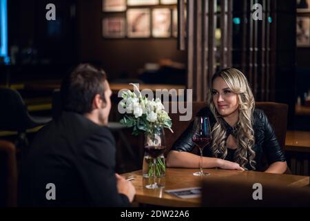 un gars et une fille sont arrivés à une première date dans un restaurant, assis à la table. Banque D'Images