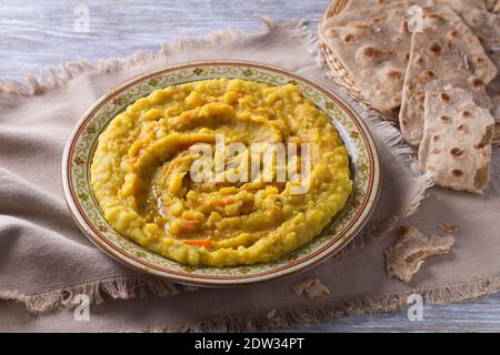 Ragoût de petits pois jaunes avec carottes, oignons et épices sur une table en bois avec chapatti, foyer sélectif Banque D'Images