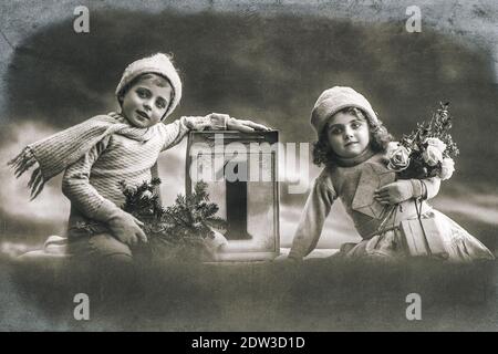 Enfants avec cadeaux et décoration. Carte postale du nouvel an vintage avec grain de film original et flou Banque D'Images