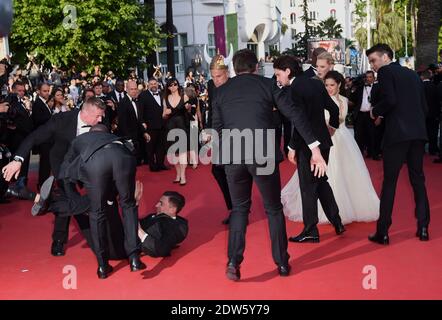 Le journaliste ukrainien Vitalii Sediuk envahit le tapis rouge en essayant de saisir la cheville de l'America Ferrera et est tenu par la sécurité lors de la projection du Dragon 2 au Palais des Festivals de Cannes, le 16 mai 2014, dans le cadre du 67ème Festival de Cannes. Photo de Lionel Hahn/ABACAPRESS.COM Banque D'Images