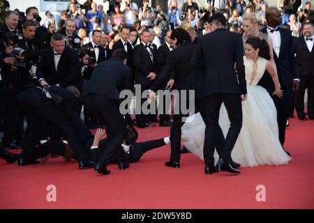 Le journaliste ukrainien Vitalii Sediuk envahit le tapis rouge en essayant de saisir la cheville de l'America Ferrera et est tenu par la sécurité lors de la projection du Dragon 2 au Palais des Festivals de Cannes, le 16 mai 2014, dans le cadre du 67ème Festival de Cannes. Photo de Nicolas Briquet/ABACAPRESS.COM Banque D'Images