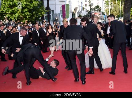 Le journaliste ukrainien Vitalii Sediuk envahit le tapis rouge en essayant de saisir la cheville de l'America Ferrera et est tenu par la sécurité lors de la projection du Dragon 2 au Palais des Festivals de Cannes, le 16 mai 2014, dans le cadre du 67ème Festival de Cannes. Photo de Lionel Hahn/ABACAPRESS.COM Banque D'Images