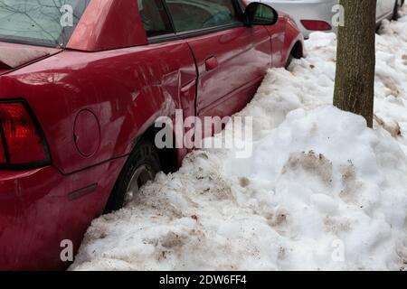 une carte rouge garée entourée de neige Banque D'Images